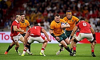 Angus Bell of Australia runs with the ball whilst under pressure from Gareth Thomas and Taulupe Faletau of Wales