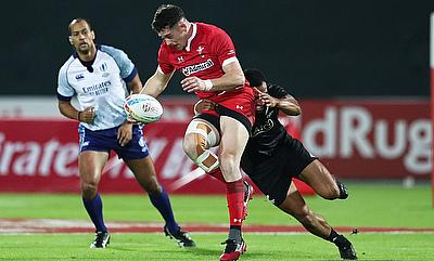 Wales' Joe Goodchild drives through the New Zealand defence on day one of the Emirates Airline Dubai Rugby Sevens