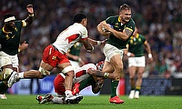 Andre Esterhuizen of South Africa runs with the ball whilst under pressure from Pita Ahki of Tonga