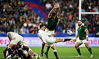 Alex Mitchell of England kicks the ball upfield whilst under pressure from Eben Etzebeth of South Africa during the World Cup semi-final