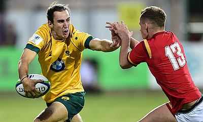 Australia's Liam McNamara tries to hand-off Welsh centre Cameron Lewis in their Pool A match at Avchala Stadium