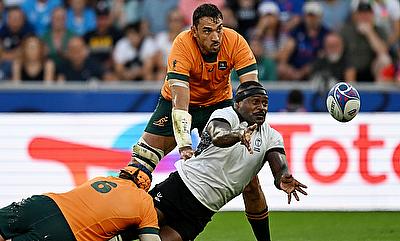 Levani Botia of Fiji passes the ball whilst under pressure from Tom Hooper and Richard Arnold of Australia