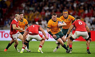 Angus Bell of Australia runs with the ball whilst under pressure from Gareth Thomas and Taulupe Faletau of Wales