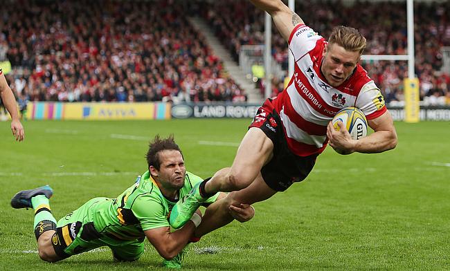 Gloucester's Jason Woodward beats the tackle of Northampton's Cobus Reinach to touch down