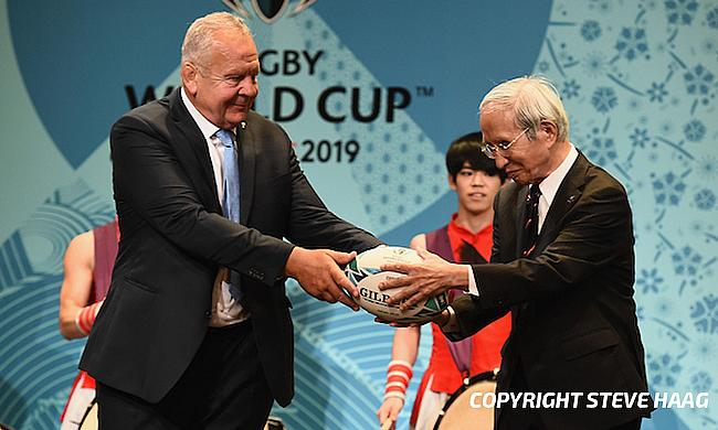 Chairman of the World Rugby Bill Beaumont passes the ball to Chairman of the Japan Rugby Football Union