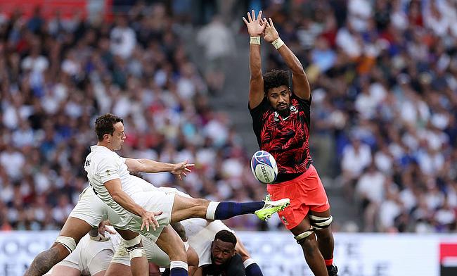 Alex Mitchell of England kicks the ball upfield whilst under pressure from Isoa Nasilasila of Fiji